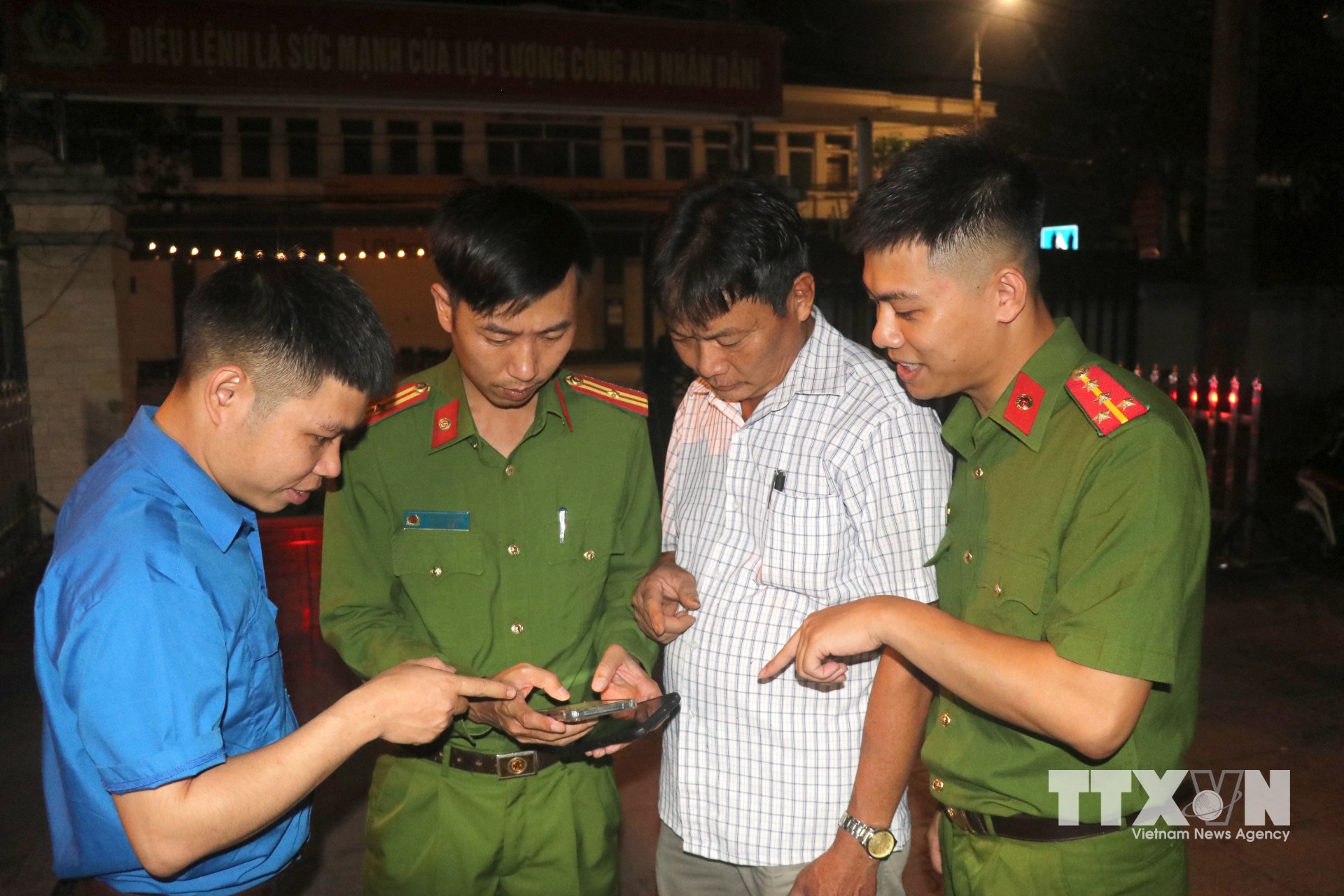 Lực lượng Công an xã Hưng Hà phối với Đoàn Thanh niên xã hướng dẫn người dân cài đặt, sử dụng ứng dụng "Báo cháy 114" trên điện thoại di động. (Ảnh: Đinh Văn Nhiều/TTXVN)